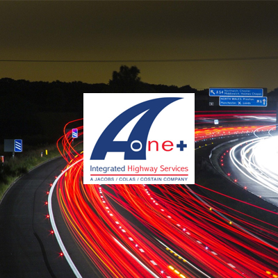 A-one+ logo in front of busy highway at night.